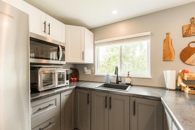 707 Coolidge Pl, Rockford, IL 61107 - kitchen featuring appliances with stainless steel finishes, a sink, white cabinets, recessed lighting, and dark countertops