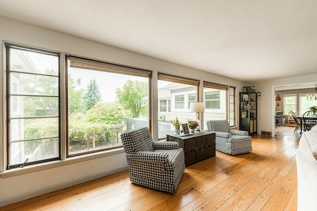 707 Coolidge Pl, Rockford, IL 61107 - living area featuring light wood-style flooring, a chandelier, and baseboards