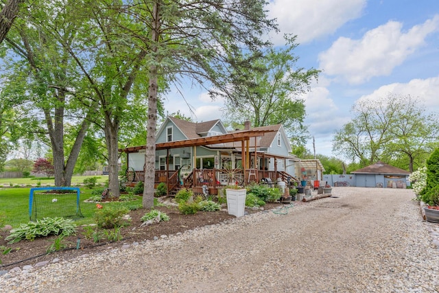 20425 N Hazelcrest Rd, Palatine, IL 60074 - view of front of house featuring covered porch, an outbuilding, a detached garage, a ceiling fan, and a chimney