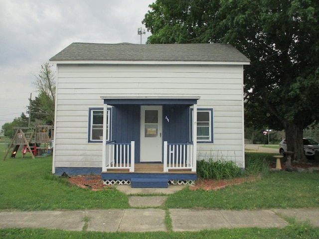 411 S Walnut St, Forreston, IL 61030 - view of front of house with a front yard, a porch, and a playground