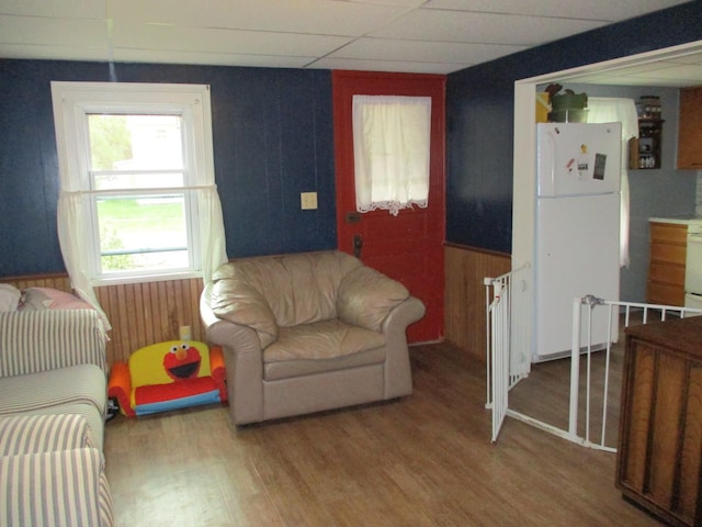 411 S Walnut St, Forreston, IL 61030 - living area with wood finished floors, wooden walls, and a paneled ceiling