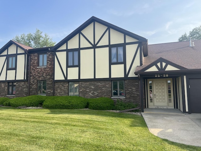 26 Crystal Ct Unit D2, Pontiac, IL 61764 - tudor house with a front yard, stucco siding, brick siding, and an attached garage
