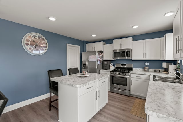 6012 Winterhaven Dr, Joliet, IL 60431 - kitchen with appliances with stainless steel finishes, a center island, a breakfast bar area, light countertops, and light wood-type flooring