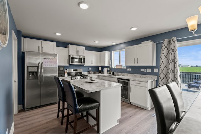 6012 Winterhaven Dr, Joliet, IL 60431 - kitchen featuring appliances with stainless steel finishes, wine cooler, light countertops, white cabinets, and recessed lighting