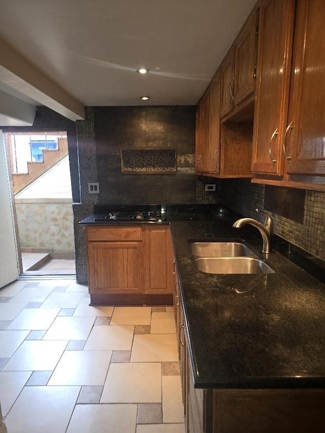 3933 N Oak Park Ave, Chicago, IL 60634 - kitchen featuring a sink, black gas stovetop, decorative backsplash, and dark stone counters