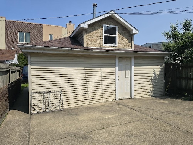 3933 N Oak Park Ave, Chicago, IL 60634 - rear view of house with a patio, roof with shingles, and stone siding