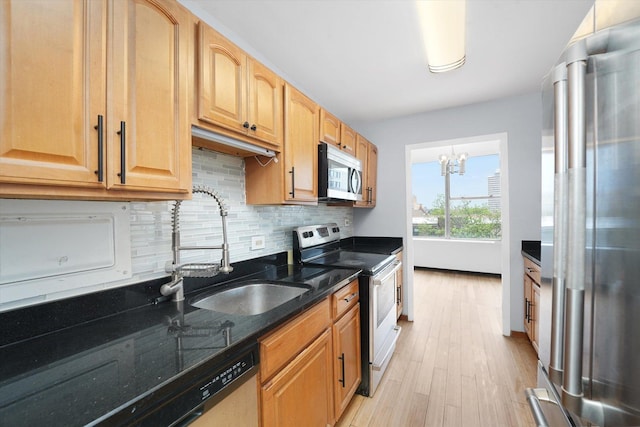 5757 N Sheridan Rd Unit 5J, Chicago, IL 60660 - kitchen featuring appliances with stainless steel finishes, tasteful backsplash, light wood-style floors, a sink, and a chandelier