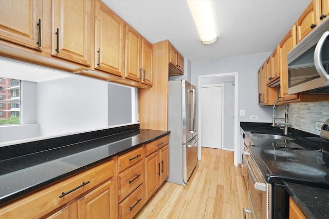5757 N Sheridan Rd Unit 5J, Chicago, IL 60660 - kitchen featuring stainless steel appliances, a sink, light wood finished floors, decorative backsplash, and dark stone countertops