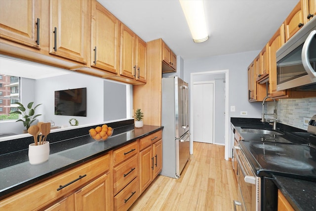 5757 N Sheridan Rd Unit 5J, Chicago, IL 60660 - kitchen with stainless steel appliances, a sink, light wood-style flooring, tasteful backsplash, and dark stone countertops