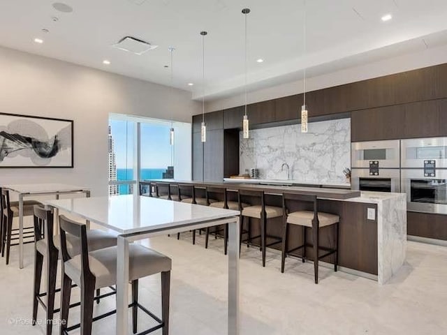363 E Wacker Dr Unit 4801, Chicago, IL 60601 - kitchen with a large island, modern cabinets, a kitchen bar, light countertops, and recessed lighting