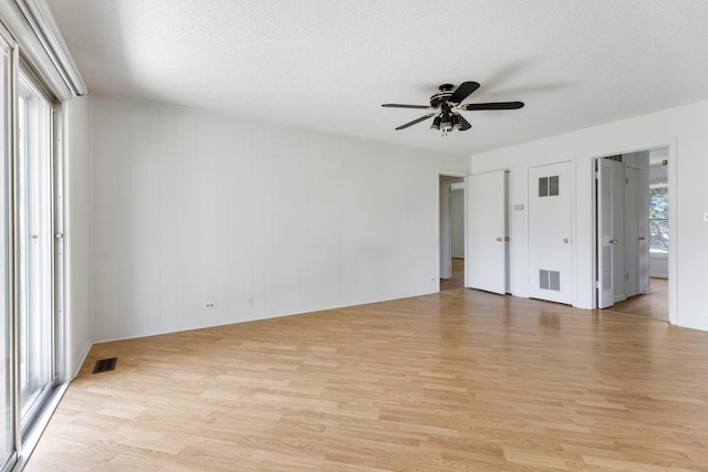 326 Dorchester Ln, Elk Grove Village, IL 60007 - unfurnished bedroom with light wood-style floors, a textured ceiling, ensuite bathroom, and ceiling fan