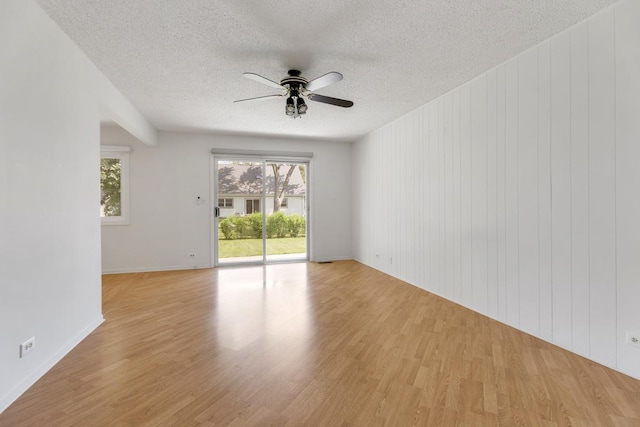 326 Dorchester Ln, Elk Grove Village, IL 60007 - unfurnished room featuring ceiling fan, a textured ceiling, light wood-style floors, and wooden walls