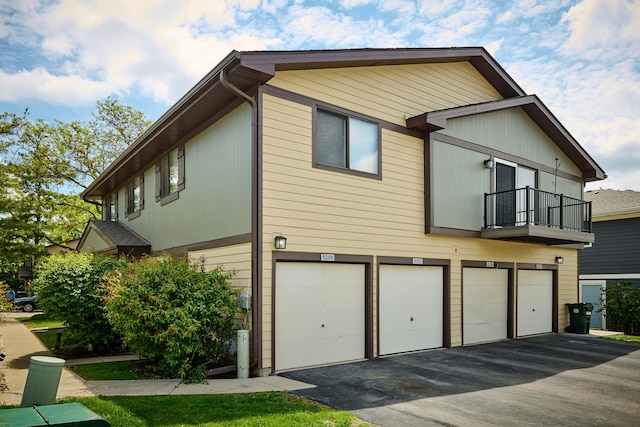 6256 Kit Carson Dr Unit 6256, Hanover Park, IL 60133 - view of property exterior featuring an attached garage, a balcony, and driveway