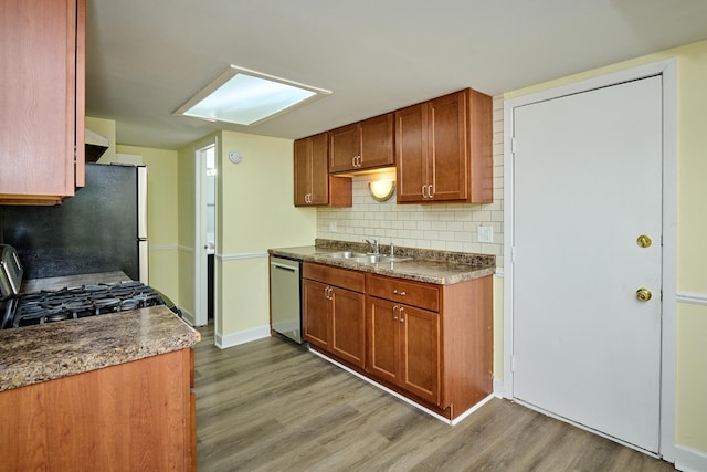 6256 Kit Carson Dr Unit 6256, Hanover Park, IL 60133 - kitchen featuring stainless steel dishwasher, a sink, light wood-style flooring, freestanding refrigerator, and tasteful backsplash