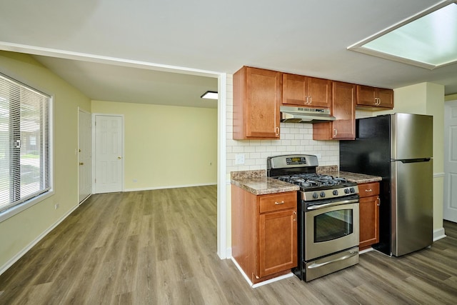 6256 Kit Carson Dr Unit 6256, Hanover Park, IL 60133 - kitchen featuring appliances with stainless steel finishes, under cabinet range hood, wood finished floors, backsplash, and baseboards