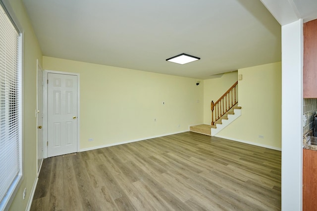6256 Kit Carson Dr Unit 6256, Hanover Park, IL 60133 - unfurnished living room featuring light wood finished floors, stairs, and baseboards