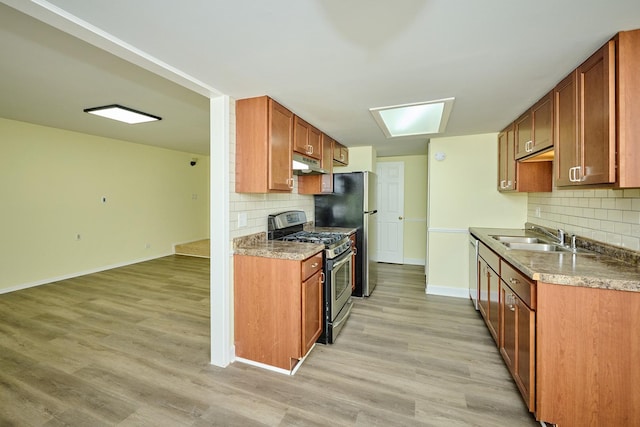 6256 Kit Carson Dr Unit 6256, Hanover Park, IL 60133 - kitchen featuring appliances with stainless steel finishes, under cabinet range hood, a sink, tasteful backsplash, and baseboards