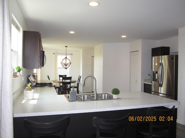 553 Hemmingsen St, Plano, IL 60545 - kitchen featuring stainless steel fridge with ice dispenser, a sink, light countertops, a peninsula, and a kitchen bar