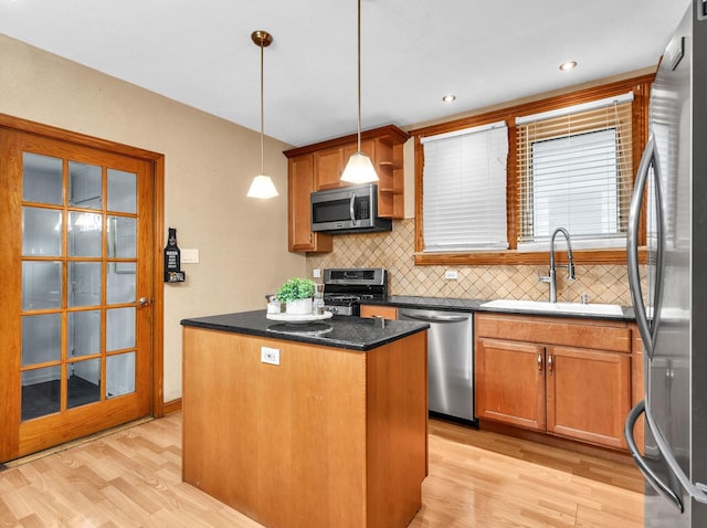 2822 N 76th Ct, Elmwood Park, IL 60707 - kitchen featuring appliances with stainless steel finishes, a sink, a center island, backsplash, and light wood-type flooring