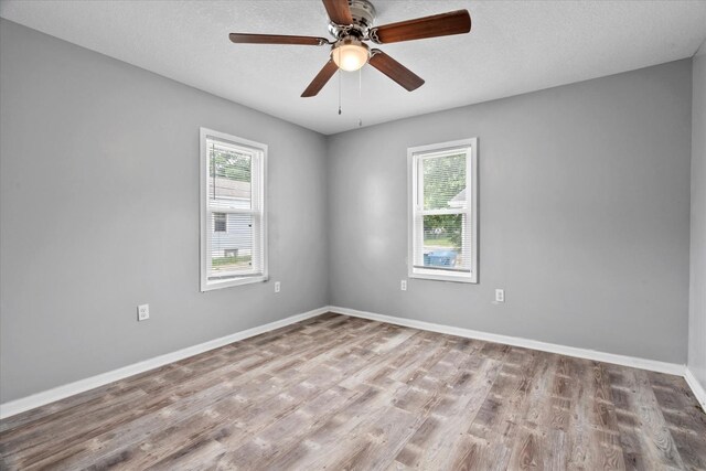 752 N 9th Ave, Kankakee, IL 60901 - empty room with healthy amount of natural light, wood finished floors, baseboards, and a textured ceiling