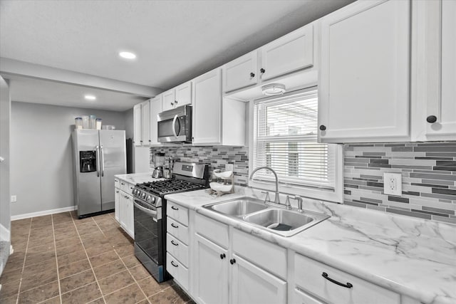 752 N 9th Ave, Kankakee, IL 60901 - kitchen featuring stainless steel appliances, a sink, white cabinets, tasteful backsplash, and baseboards
