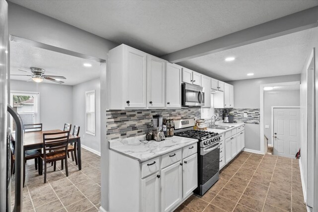 752 N 9th Ave, Kankakee, IL 60901 - kitchen with stainless steel appliances, a sink, a textured ceiling, backsplash, and white cabinets