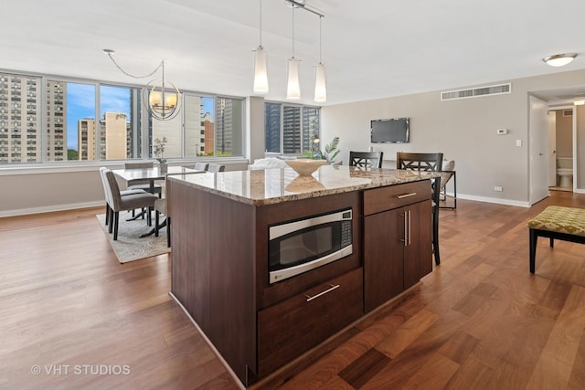 1 E Schiller St Unit 10B, Chicago, IL 60610 - kitchen with stainless steel microwave, dark wood-type flooring, baseboards, and dark brown cabinetry
