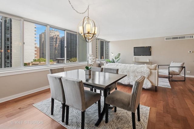 1 E Schiller St Unit 10B, Chicago, IL 60610 - dining space with a chandelier, baseboards, and wood finished floors