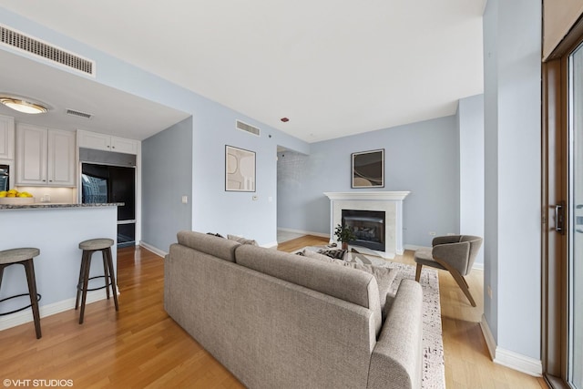 21 E Huron St Unit 1101, Chicago, IL 60611 - living room with a premium fireplace, light wood-type flooring, and baseboards