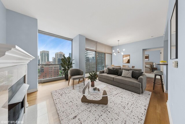21 E Huron St Unit 1101, Chicago, IL 60611 - living area featuring a chandelier, a view of city, a tile fireplace, light wood-style floors, and expansive windows