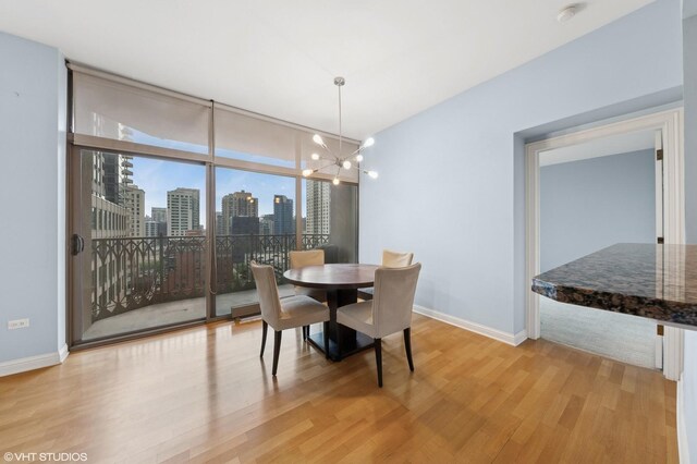 21 E Huron St Unit 1101, Chicago, IL 60611 - dining area featuring light wood-type flooring, floor to ceiling windows, a chandelier, baseboards, and a skyline view