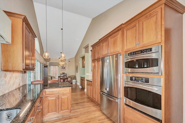 20400 Mackinac Point Dr, Frankfort, IL 60423 - kitchen featuring appliances with stainless steel finishes, vaulted ceiling, light wood finished floors, dark stone counters, and decorative backsplash