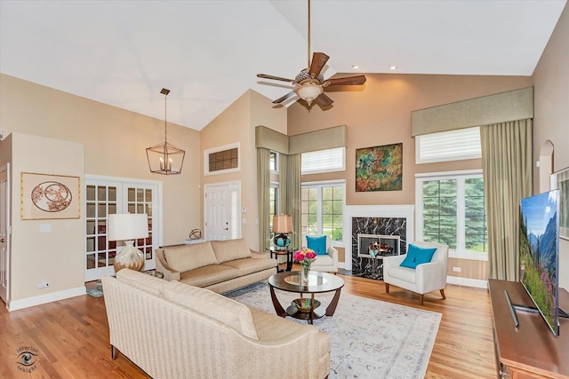 20400 Mackinac Point Dr, Frankfort, IL 60423 - living room with high vaulted ceiling, light wood finished floors, a ceiling fan, a fireplace, and a chandelier