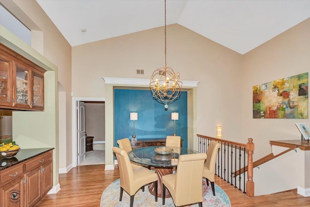 20400 Mackinac Point Dr, Frankfort, IL 60423 - dining room featuring a chandelier, light wood finished floors, high vaulted ceiling, and arched walkways