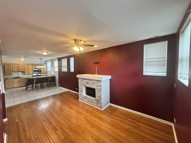 1430 E 69th St Unit 1S, Chicago, IL 60637 - living room featuring baseboards, light wood-type flooring, ceiling fan, and a fireplace