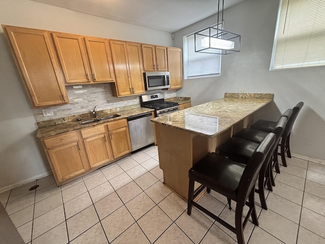 1430 E 69th St Unit 1S, Chicago, IL 60637 - kitchen featuring appliances with stainless steel finishes, a sink, tasteful backsplash, a peninsula, and a kitchen bar