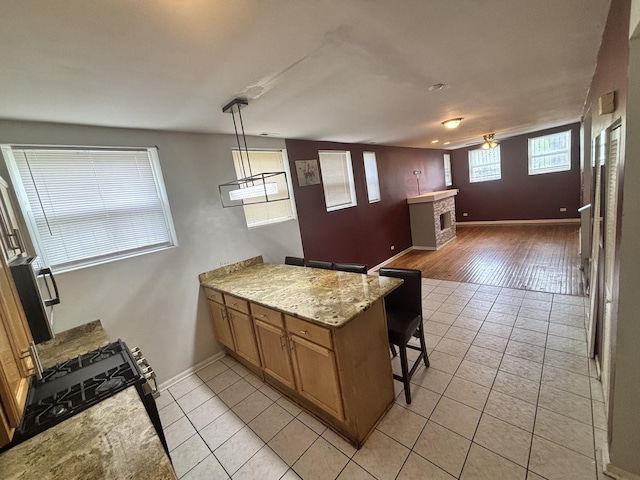 1430 E 69th St Unit 1S, Chicago, IL 60637 - kitchen with a peninsula, light tile patterned floors, a fireplace, and baseboards