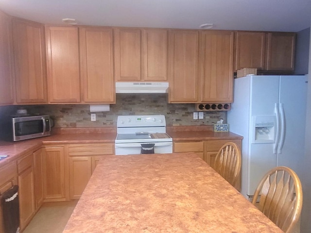 626 Sedgegrass Dr, Champaign, IL 61822 - kitchen with under cabinet range hood, white appliances, light countertops, and backsplash