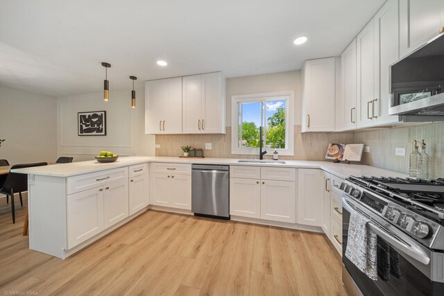 21W040 Monticello Rd, Lombard, IL 60148 - kitchen featuring stainless steel appliances, a peninsula, a sink, decorative backsplash, and light wood-type flooring