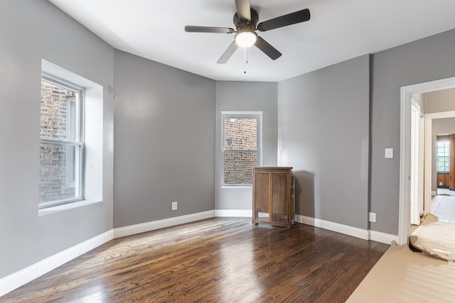 unfurnished bedroom with wood finished floors, baseboards, and a ceiling fan