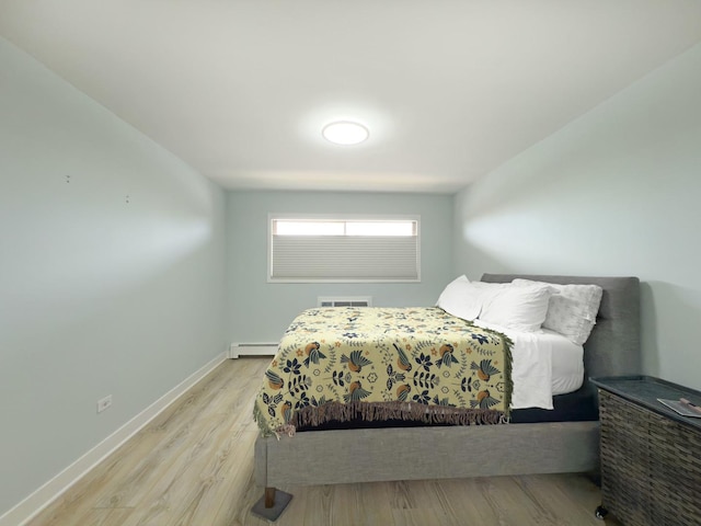 120 Collen Dr Unit 219, Lombard, IL 60148 - bedroom featuring a baseboard heating unit, light wood-style floors, and baseboards