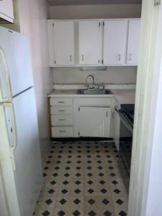 5415 N Sheridan Rd Unit 1210, Chicago, IL 60640 - kitchen with freestanding refrigerator, a sink, white cabinetry, and light countertops