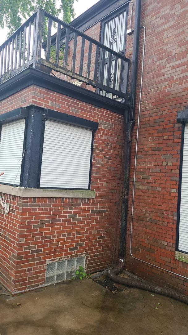 8214 S Yates Blvd, Chicago, IL 60617 - view of home's exterior featuring a balcony and brick siding
