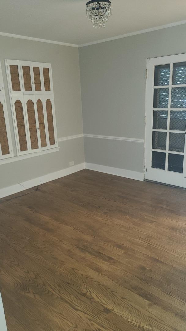 8214 S Yates Blvd, Chicago, IL 60617 - spare room with ornamental molding, dark wood-style flooring, a chandelier, and baseboards