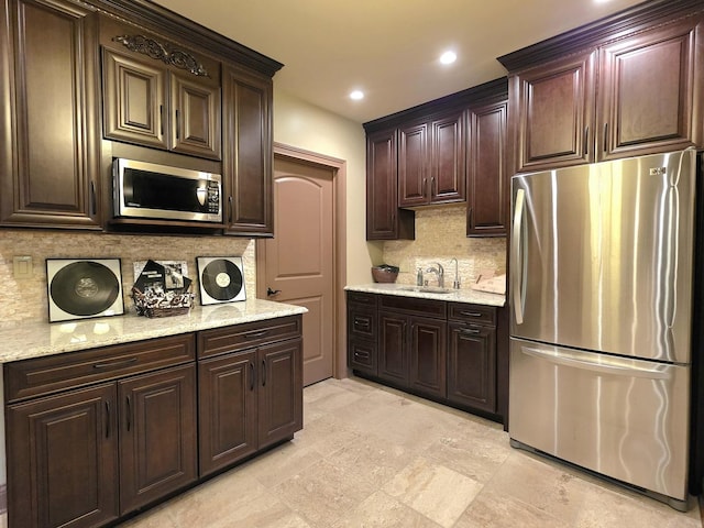 18545 S Marilynn Ct, Mokena, IL 60448 - kitchen with stainless steel appliances, backsplash, dark brown cabinetry, light stone countertops, and recessed lighting