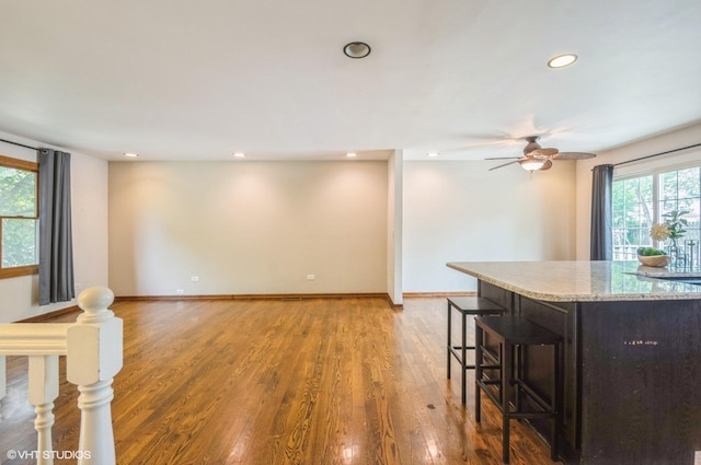 6407 Hillcrest Rd, Cary, IL 60013 - kitchen featuring a kitchen breakfast bar, light wood-style flooring, recessed lighting, ceiling fan, and light stone countertops