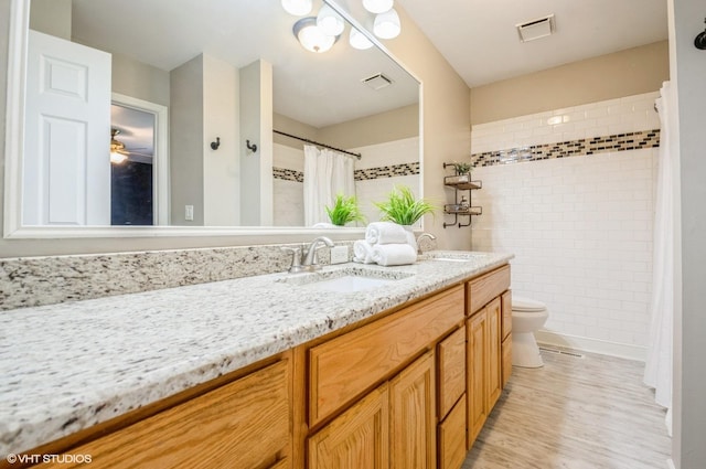 6407 Hillcrest Rd, Cary, IL 60013 - bathroom featuring toilet, double vanity, a tile shower, and wood finished floors