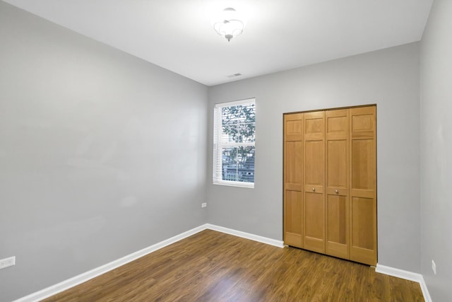 2215 Aurora Dr Unit 1, Pingree Grove, IL 60140 - unfurnished bedroom with dark wood-style flooring, baseboards, and a closet