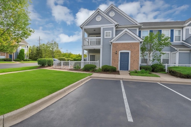 2215 Aurora Dr Unit 1, Pingree Grove, IL 60140 - view of front of property featuring a balcony, uncovered parking, and brick siding