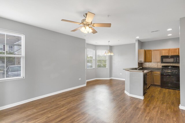 2215 Aurora Dr Unit 1, Pingree Grove, IL 60140 - kitchen with black microwave, stove, baseboards, tasteful backsplash, and a chandelier